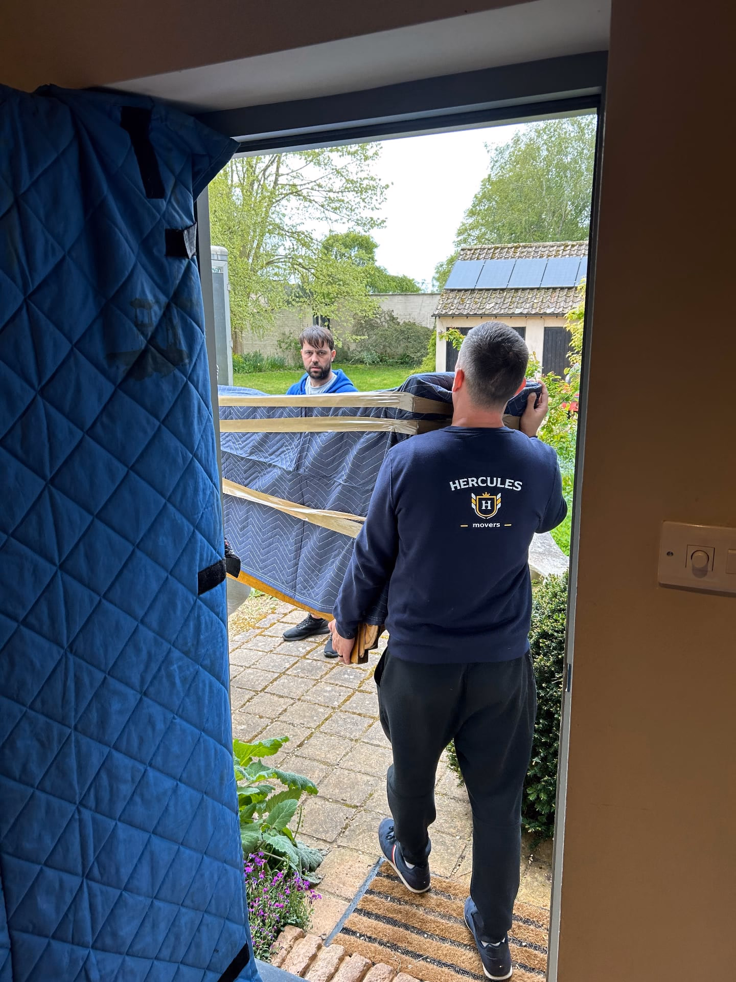 Hercules movers wrapping piano