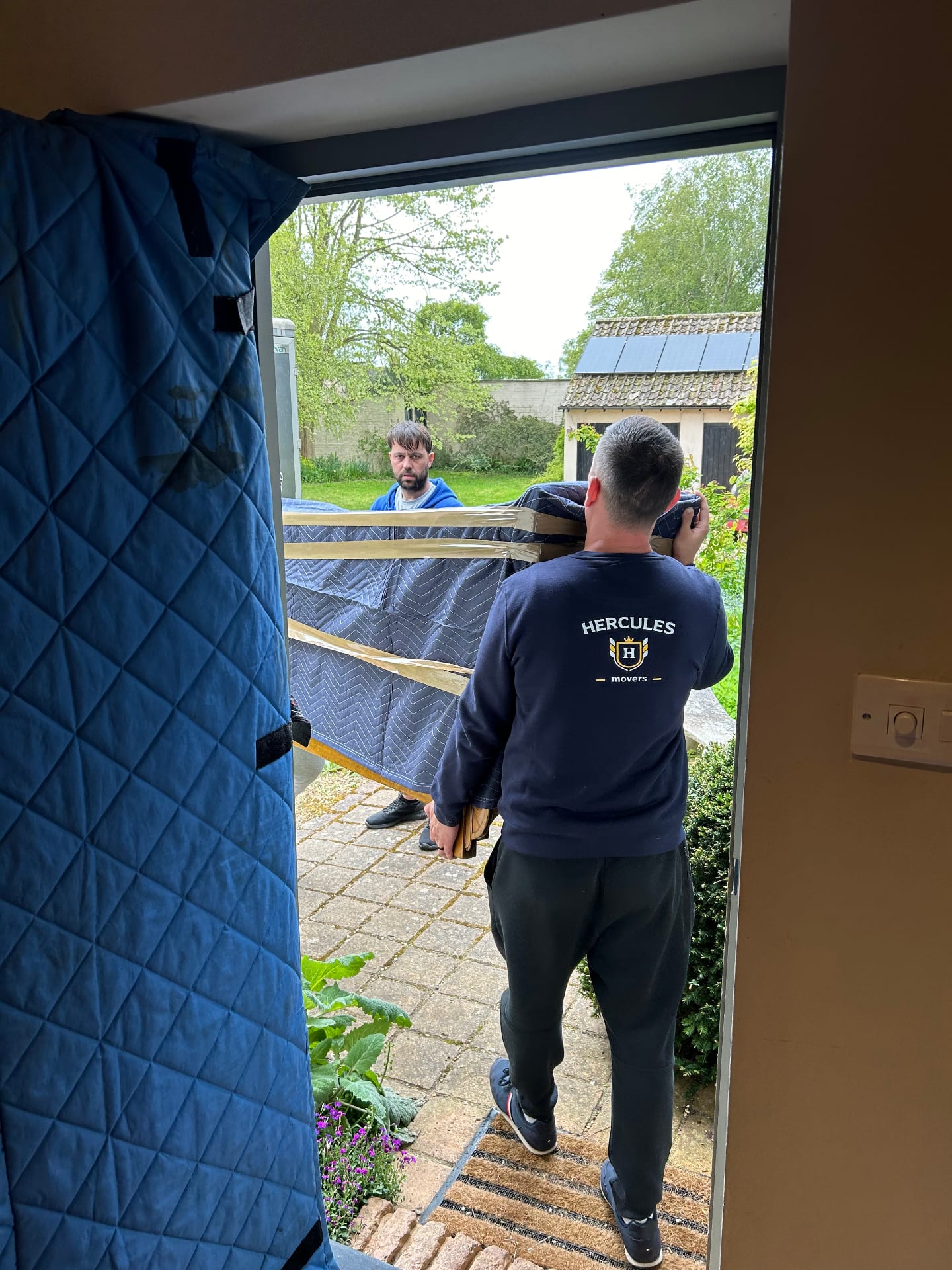 Hercules movers wrapping piano
