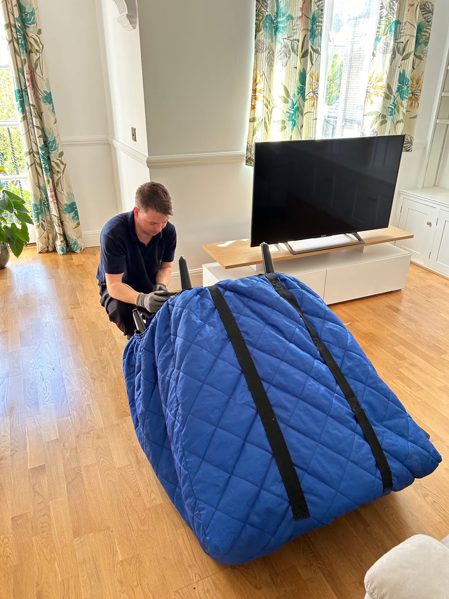 Two movers wrapping sofa