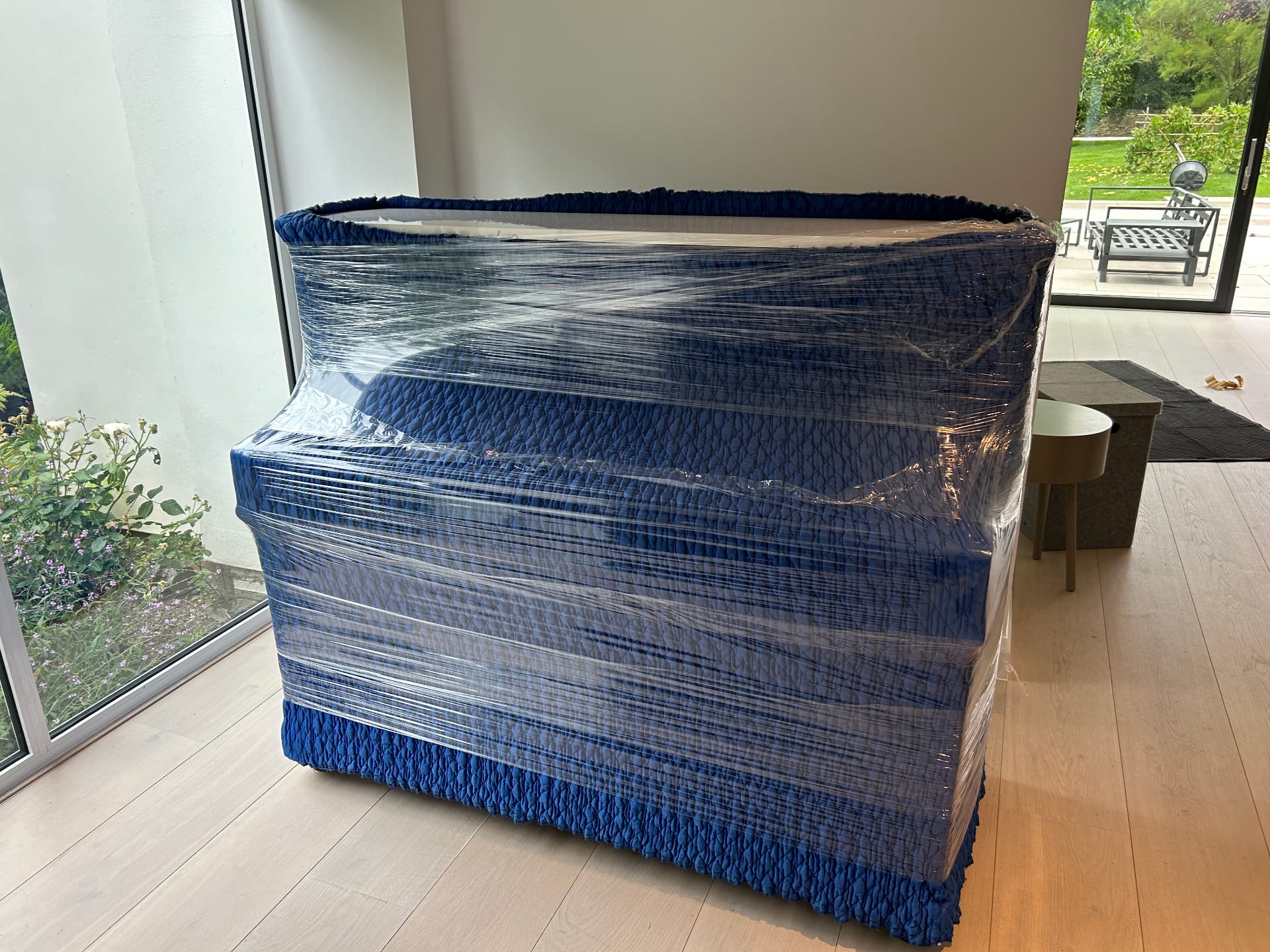 Padded grand piano secured for a Cambridge move